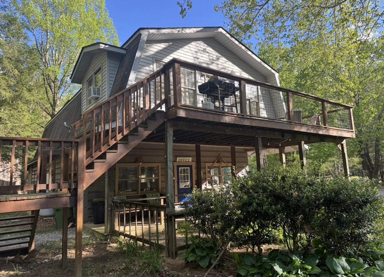 Lodge and cabin exterior with deck and office door at Bluehead Waters